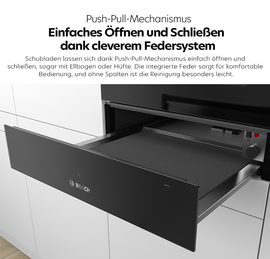 Feature-Banner,Geöffnete Bosch Wärmeschublade mit Push-Pull-Mechanismus und schwarzer Front in moderner Küchenzeile.'