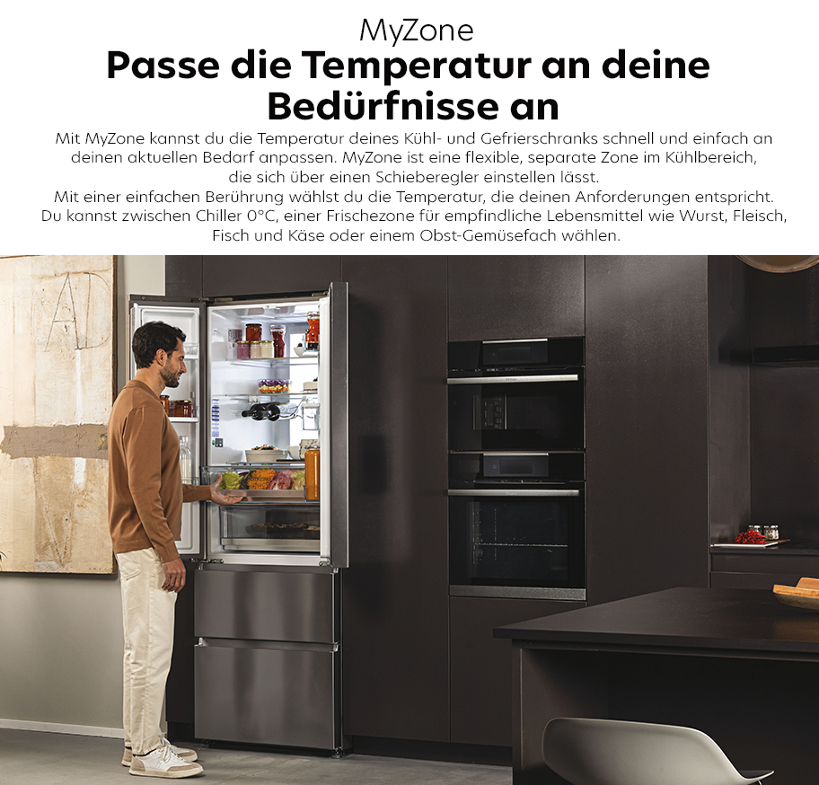 Feature-Banner für Mann steht vor offenem Haier MyZone Kühlschrank mit mehreren Fächern, in moderner Küche mit schwarzen Einbauschränken und Geräten