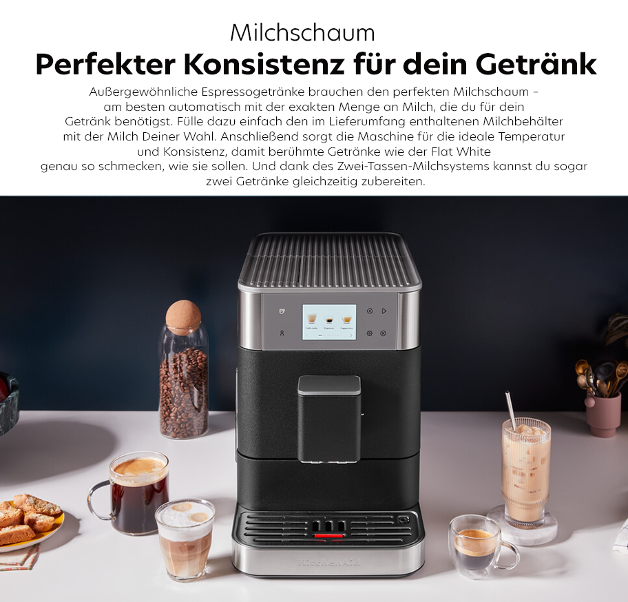 Feature-Banner, Küchenmaschine von KitchenAid in Schwarz mit Milchaufschäumer, umgeben von Tassen mit verschiedenen Getränken. Text: 'Milchschaum Perfekter Konsistenz für dein Getränk'.