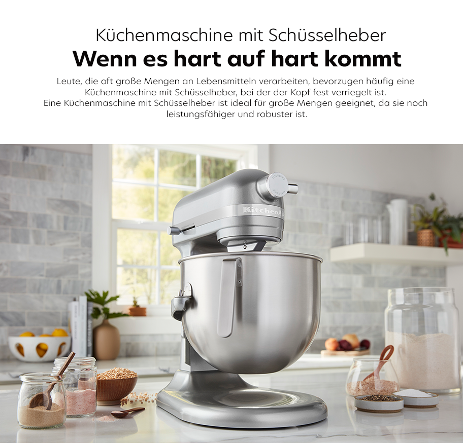 Feature-Banner, Küchenmaschine von KitchenAid mit Schüsselheber in silberner Farbe, auf einer Küchenarbeitsplatte, umgeben von Zutaten in Gläsern.'.