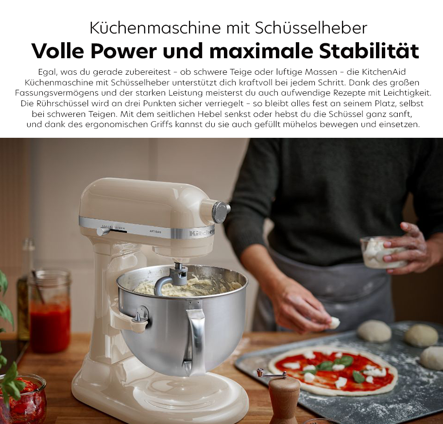 Feature-Banner, Küchenmaschine von KitchenAid in Cremefarbe mit Schüsselheber, auf einer Arbeitsfläche. Eine Schüssel mit Teig ist auf der Maschine, daneben ein roter Teig auf einem Holzbrett. Text: 'Küchenmaschine mit Schüsselheber Volle Power und maximale Stabilität'.