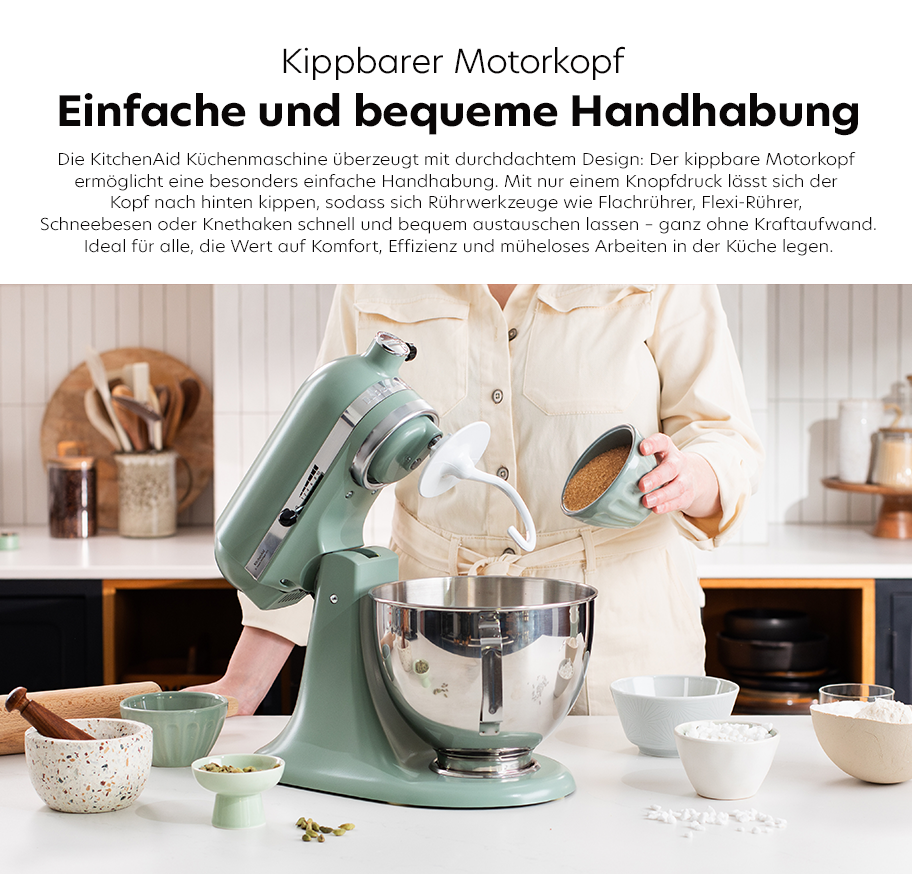Feature-Banner, Küchenmaschine von KitchenAid in mintgrün mit kippbarem Motorkopf. Person in beiger Bluse steht am Tisch mit Schüsseln und Rührbesen'.