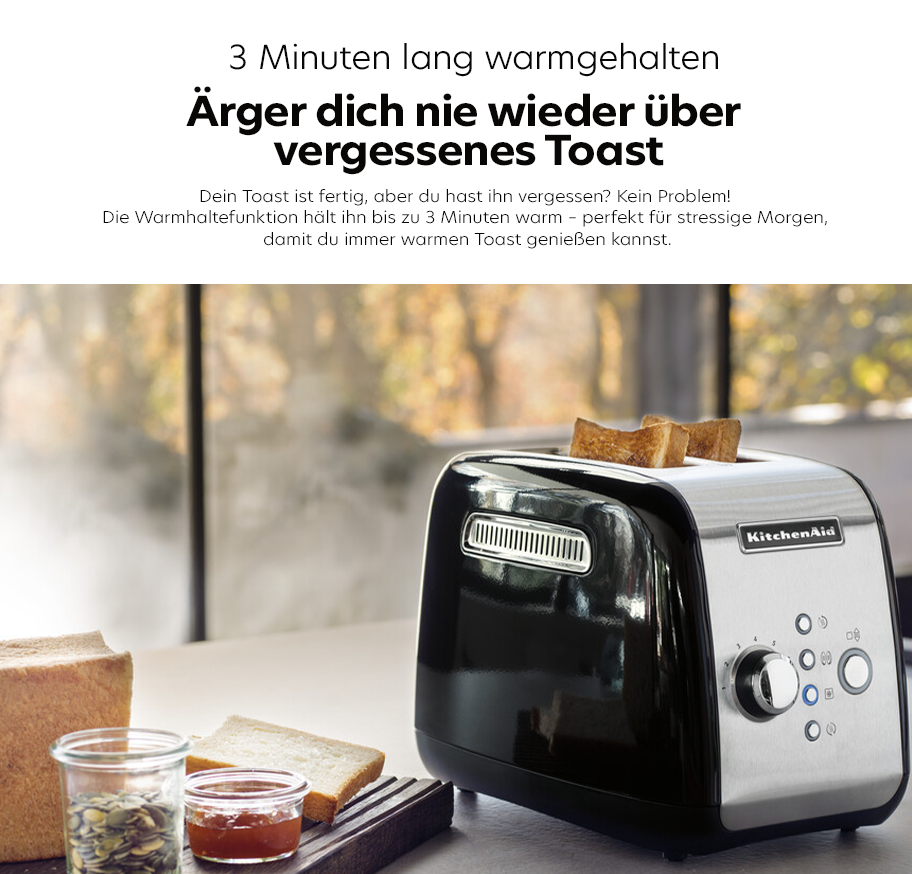 Feature-Banner, Küchenmaschine KitchenAid Toaster in Schwarz und Edelstahl mit zwei Toastscheiben, daneben Glas mit Müsli und Marmelade, Text über 3 Minuten Warmhaltefunktion.'