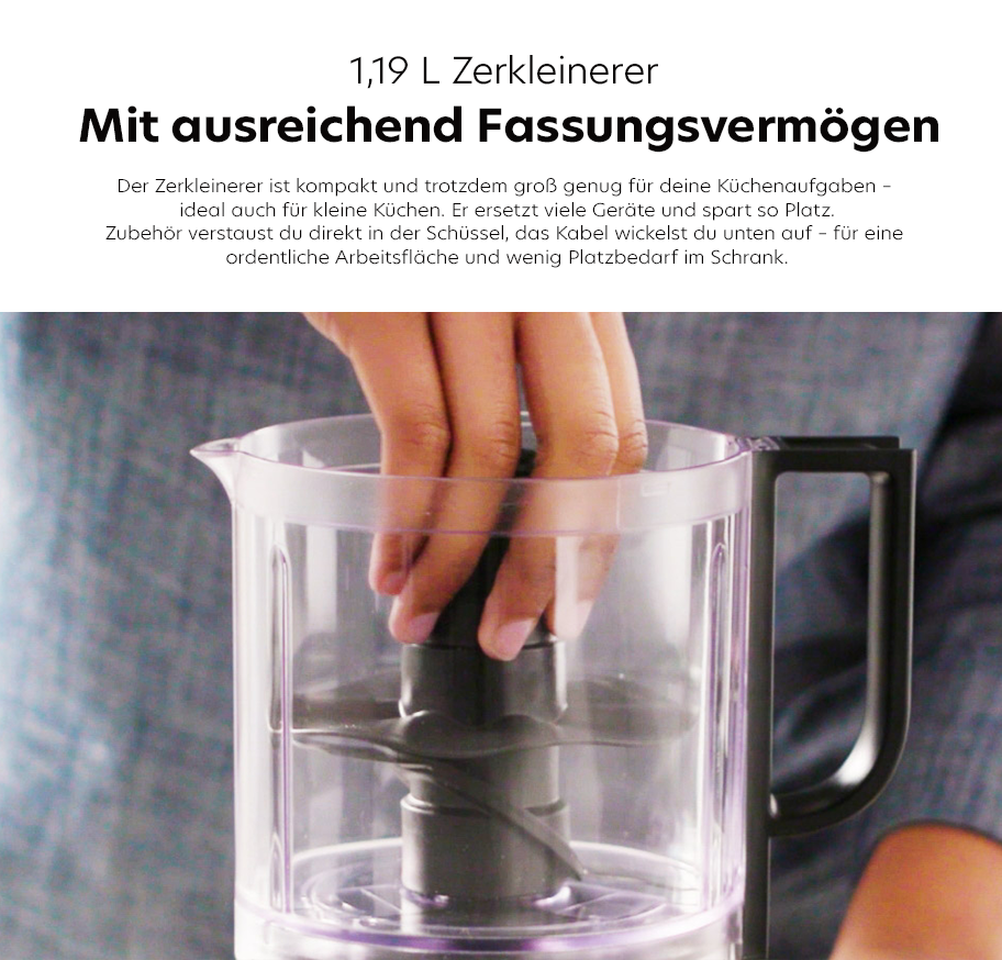Feature-Banner, Hand greift in transparenten Zerkleinerer mit schwarzem Griff und Rührstäben im Hintergrund.'